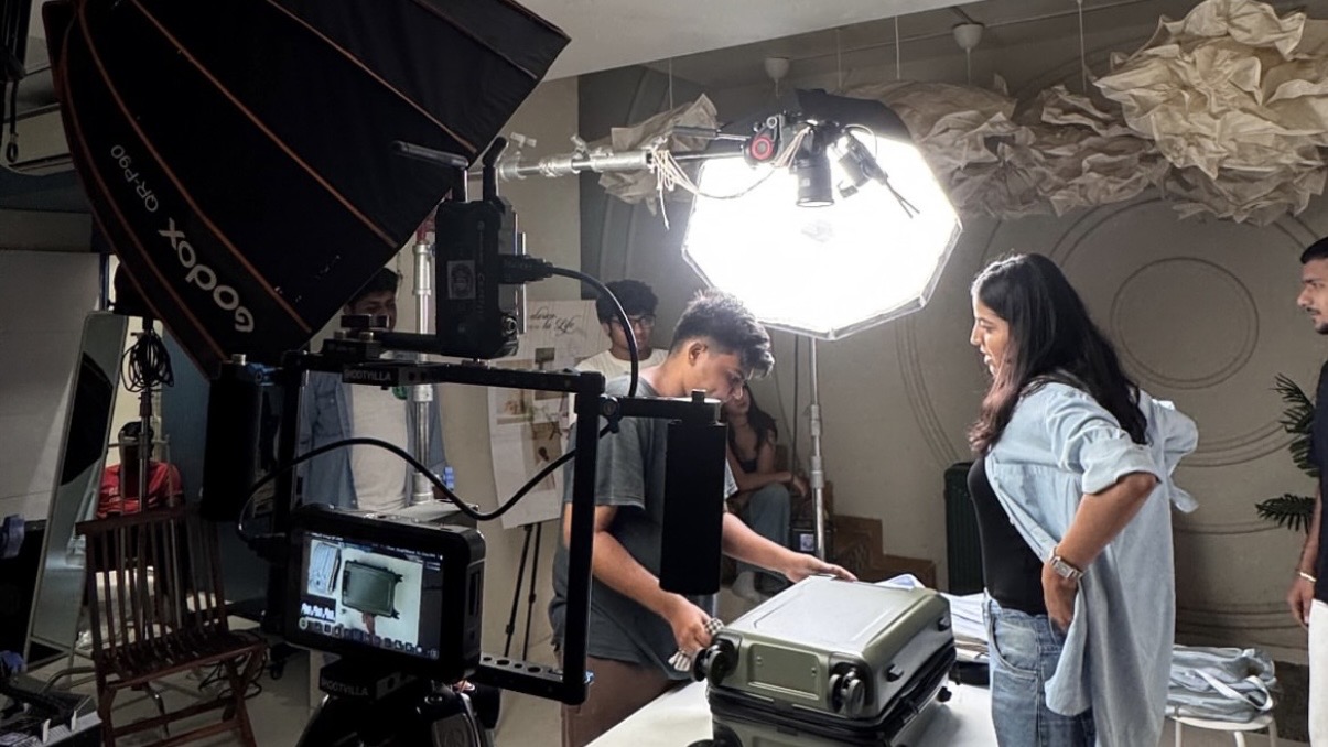 Crew lighting a tabletop product set under a large overhead softbox