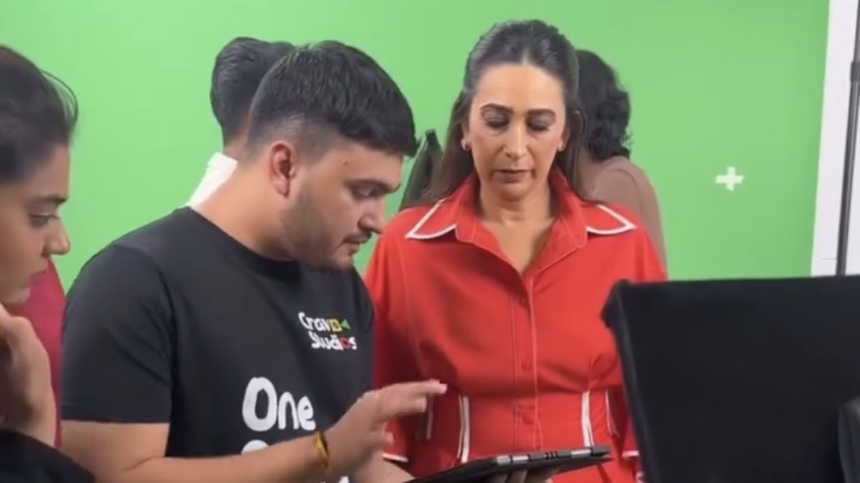 Actress reviewing a take on a tablet in front of the green screen