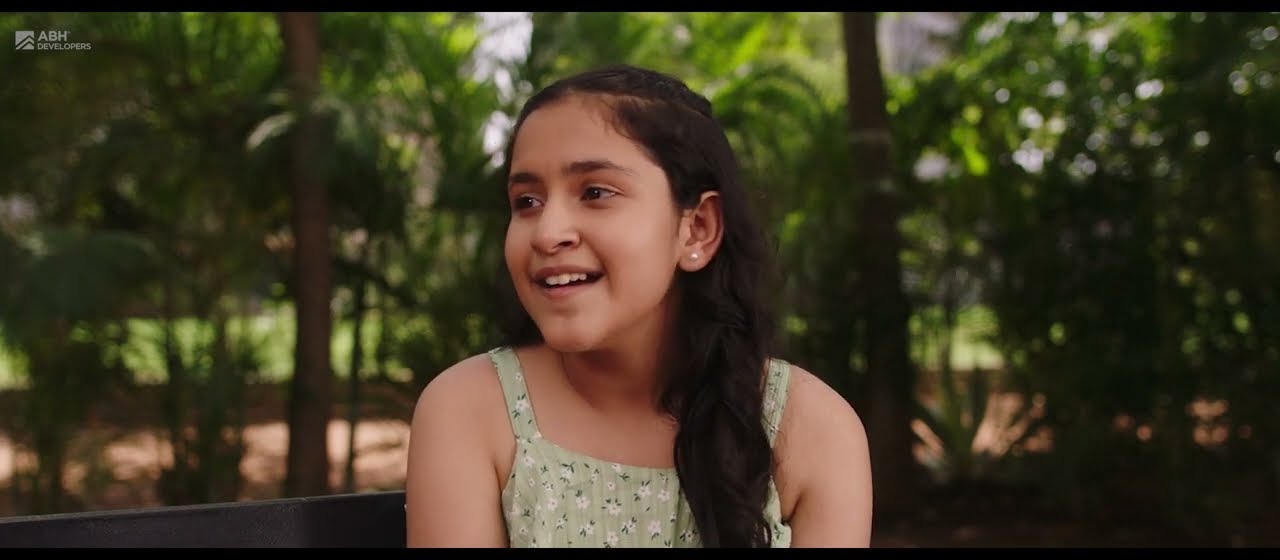 A young girl smiling among trees in a frame from the Treeland film series